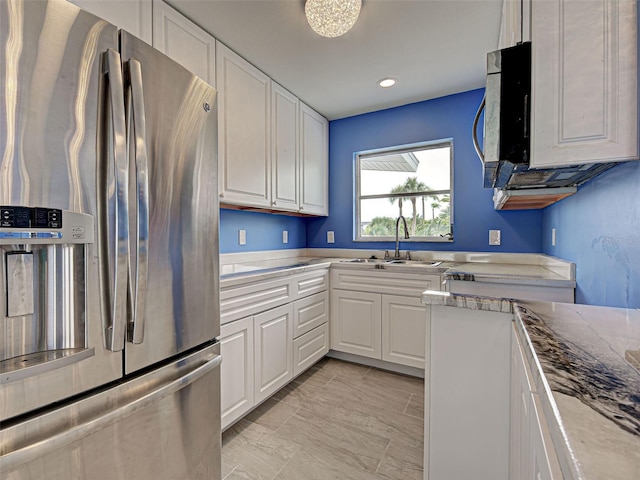 1295 S Maryknoll Rd, Englewood, FL 34223 - kitchen with stainless steel appliances, white cabinets, light marble finish floors, recessed lighting, and light stone countertops