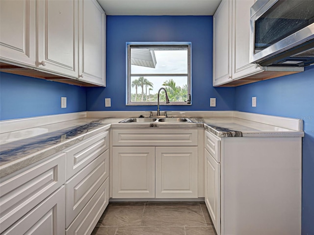 1295 S Maryknoll Rd, Englewood, FL 34223 - kitchen with stainless steel microwave, white cabinets, and light countertops