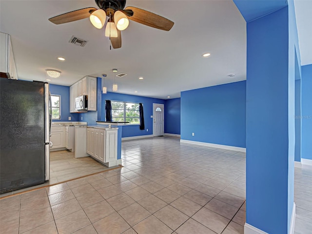 1295 S Maryknoll Rd, Englewood, FL 34223 - kitchen featuring stainless steel appliances, open floor plan, ceiling fan, light tile patterned flooring, and white cabinetry
