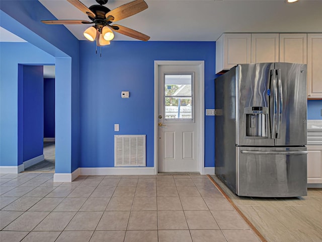 1295 S Maryknoll Rd, Englewood, FL 34223 - kitchen with stainless steel fridge, white cabinets, a ceiling fan, and light tile patterned flooring