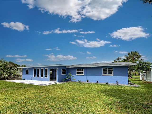 1295 S Maryknoll Rd, Englewood, FL 34223 - rear view of house featuring stucco siding, a lawn, and a patio