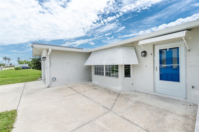 39 Caddy Rd, Rotonda West, FL 33947 - back of property featuring stucco siding and a patio