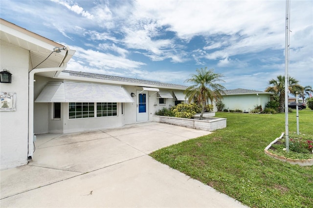 39 Caddy Rd, Rotonda West, FL 33947 - view of front of property with a front lawn, stucco siding, and a patio area
