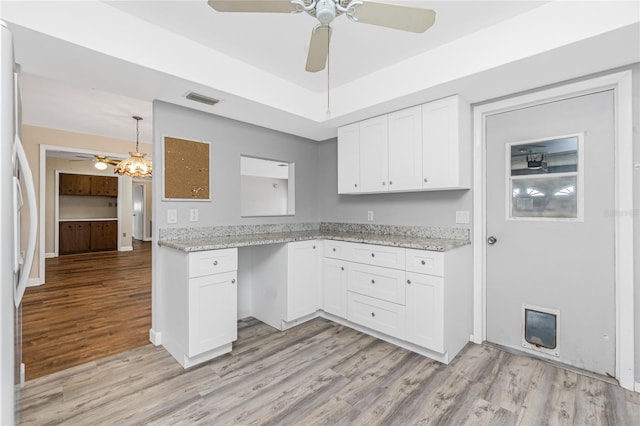 39 Caddy Rd, Rotonda West, FL 33947 - kitchen with a ceiling fan, light wood finished floors, white cabinetry, light stone countertops, and fridge