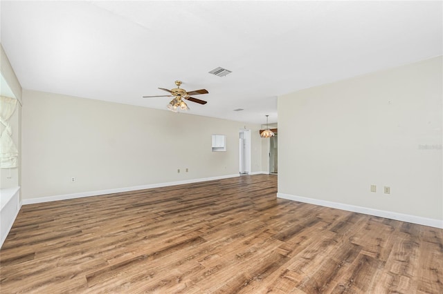 39 Caddy Rd, Rotonda West, FL 33947 - empty room with wood finished floors, ceiling fan, and a chandelier