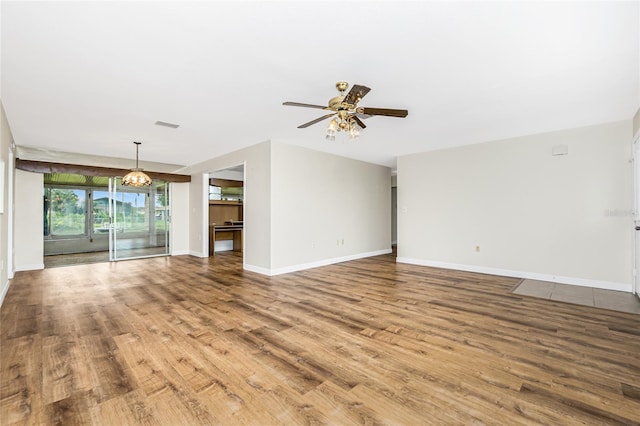 39 Caddy Rd, Rotonda West, FL 33947 - unfurnished living room featuring wood finished floors, a ceiling fan, and a chandelier