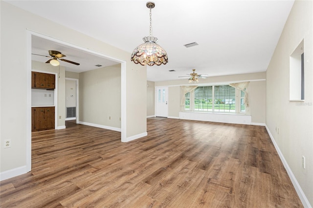 39 Caddy Rd, Rotonda West, FL 33947 - unfurnished living room with ceiling fan, wood finished floors, and a chandelier