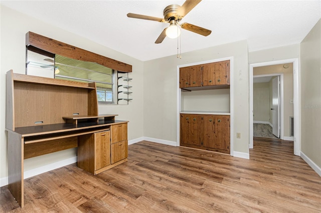 39 Caddy Rd, Rotonda West, FL 33947 - unfurnished office featuring ceiling fan, wood finished floors, and built in desk