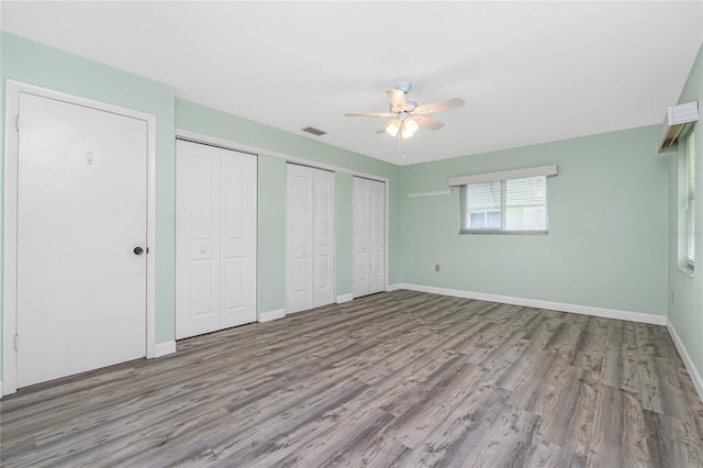 39 Caddy Rd, Rotonda West, FL 33947 - unfurnished bedroom with multiple closets, wood finished floors, and a ceiling fan