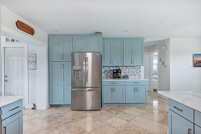 1030 Haste Ln, Englewood, FL 34223 - kitchen featuring stainless steel refrigerator with ice dispenser, backsplash, and light stone countertops