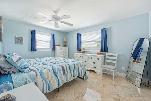 1030 Haste Ln, Englewood, FL 34223 - bedroom with multiple windows, ceiling fan, and light stone finish flooring