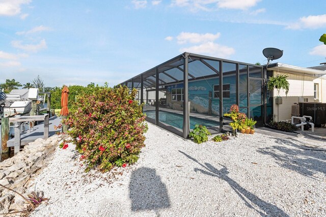 1030 Haste Ln, Englewood, FL 34223 - back of house with an outdoor pool and glass enclosure
