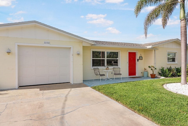 1030 Haste Ln, Englewood, FL 34223 - single story home featuring driveway, a front lawn, concrete block siding, a garage, and roof with shingles
