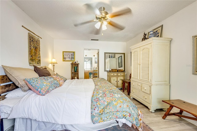 7104 Castilla St, Port Charlotte, FL 33981 - bedroom featuring light wood-style flooring, a textured ceiling, a ceiling fan, and ensuite bath