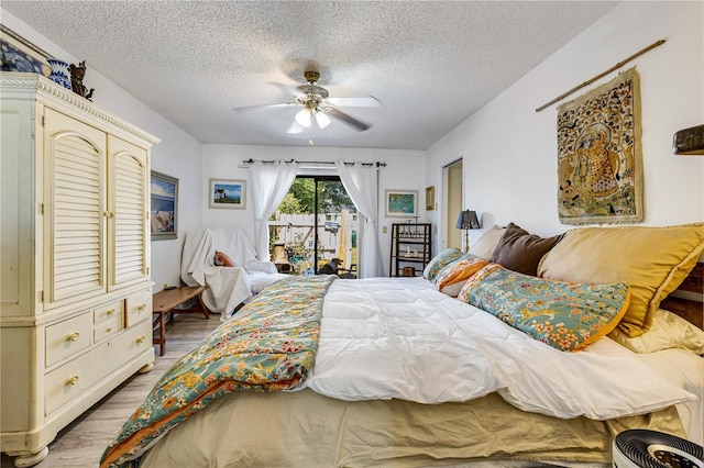 7104 Castilla St, Port Charlotte, FL 33981 - bedroom with access to outside, light wood-style flooring, a textured ceiling, and a ceiling fan