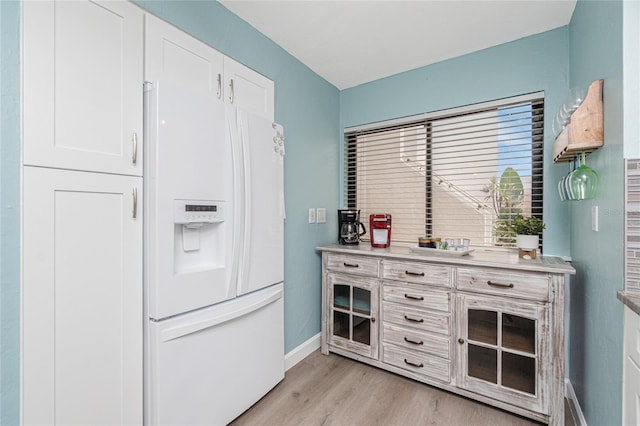2955 N Beach Rd Unit A411, Englewood, FL 34223 - kitchen with white fridge with ice dispenser, light wood-type flooring, white cabinets, and light countertops