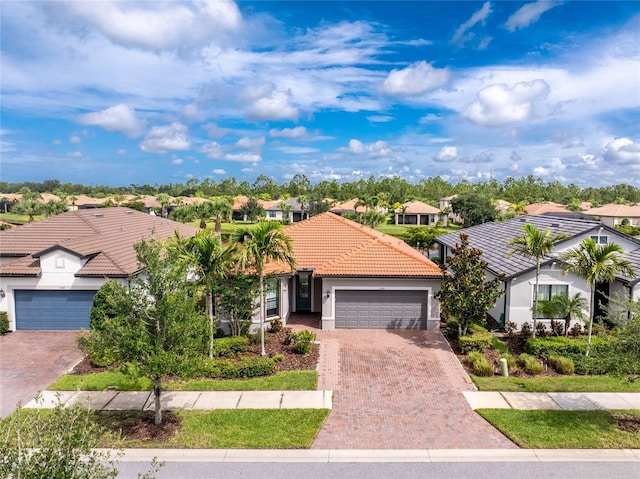 1530 Hyssop Loop, North Port, FL 34289 - mediterranean / spanish-style house featuring a tiled roof, a residential view, a garage, stucco siding, and decorative driveway