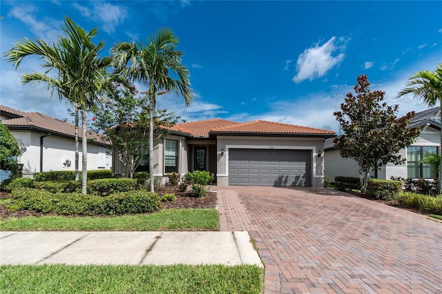 1530 Hyssop Loop, North Port, FL 34289 - view of front of house with a tile roof, an attached garage, stucco siding, and decorative driveway