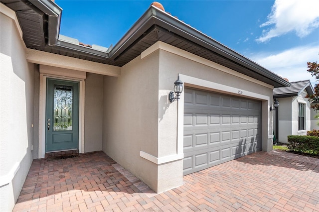 1530 Hyssop Loop, North Port, FL 34289 - entrance to property featuring stucco siding, an attached garage, and decorative driveway