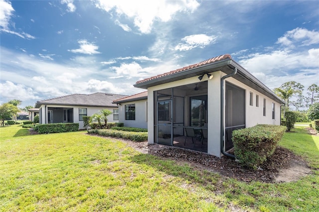 1530 Hyssop Loop, North Port, FL 34289 - rear view of house featuring a sunroom, a lawn, and stucco siding