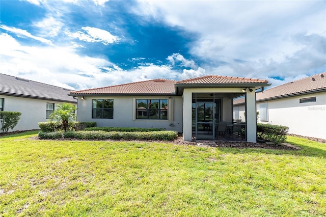 1530 Hyssop Loop, North Port, FL 34289 - back of property with a tile roof, a sunroom, a lawn, and stucco siding