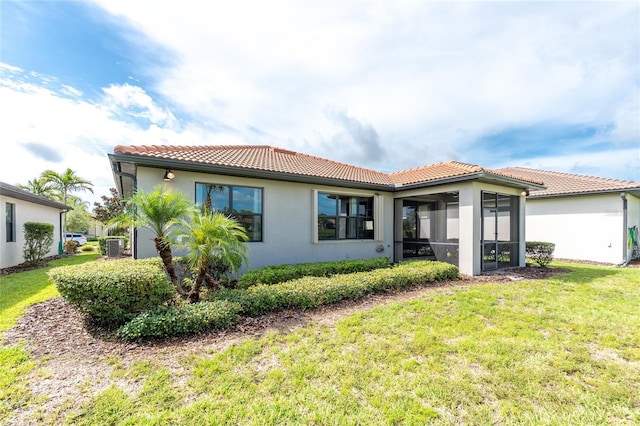 1530 Hyssop Loop, North Port, FL 34289 - back of property with a tile roof, a yard, a sunroom, and stucco siding