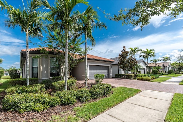 1530 Hyssop Loop, North Port, FL 34289 - view of front of property with stucco siding, a tile roof, decorative driveway, and an attached garage