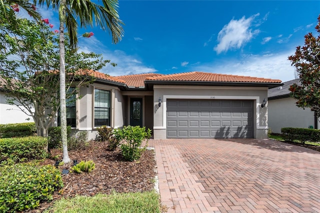 1530 Hyssop Loop, North Port, FL 34289 - view of front of house featuring stucco siding, a tile roof, and a garage