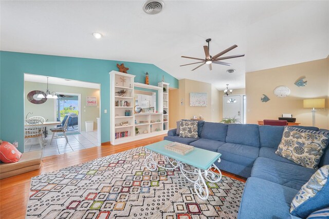 7453 Spinnaker Blvd, Englewood, FL 34224 - living area with a chandelier, vaulted ceiling, wood finished floors, and ceiling fan