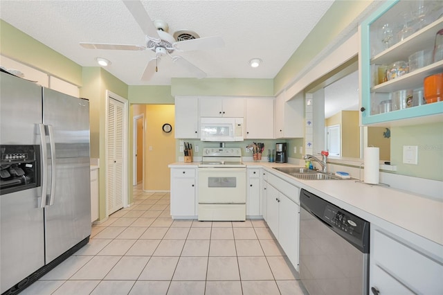 7453 Spinnaker Blvd, Englewood, FL 34224 - kitchen with appliances with stainless steel finishes, light countertops, a ceiling fan, white cabinets, and a textured ceiling