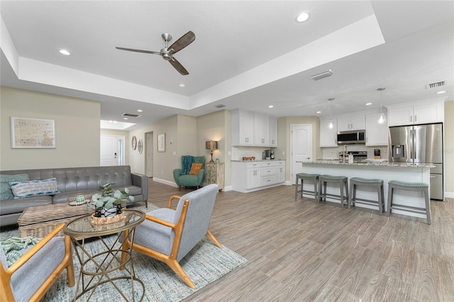 184 Spring Dr, Rotonda West, FL 33947 - living room featuring recessed lighting, ceiling fan, light wood-style floors, and a raised ceiling
