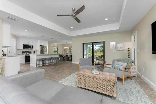 184 Spring Dr, Rotonda West, FL 33947 - living area featuring light wood finished floors, ceiling fan, recessed lighting, and a tray ceiling