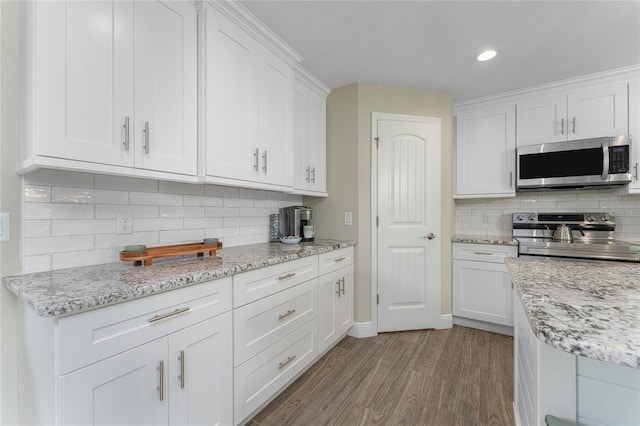 184 Spring Dr, Rotonda West, FL 33947 - kitchen with appliances with stainless steel finishes, wood finished floors, white cabinetry, decorative backsplash, and recessed lighting