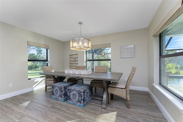 184 Spring Dr, Rotonda West, FL 33947 - dining area with a chandelier, wood finished floors, and healthy amount of natural light