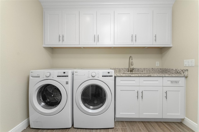184 Spring Dr, Rotonda West, FL 33947 - washroom with cabinet space, independent washer and dryer, and light wood-style floors