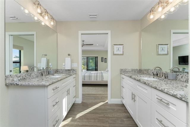 184 Spring Dr, Rotonda West, FL 33947 - ensuite bathroom featuring two vanities, wood finished floors, and ceiling fan