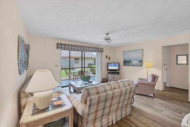 2004 Longpointe Cir Unit E2, Venice, FL 34293 - living area featuring light wood-style floors, a textured ceiling, and ceiling fan