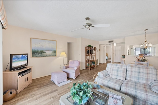2004 Longpointe Cir Unit E2, Venice, FL 34293 - living room featuring light wood-style flooring, a chandelier, ceiling fan, and a textured ceiling