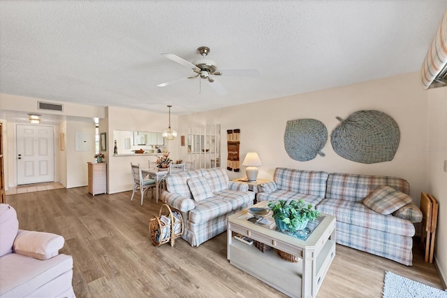 2004 Longpointe Cir Unit E2, Venice, FL 34293 - living room with light wood-style floors, a textured ceiling, and a ceiling fan