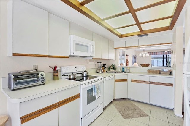 2004 Longpointe Cir Unit E2, Venice, FL 34293 - kitchen featuring white appliances, light countertops, white cabinets, and light tile patterned floors