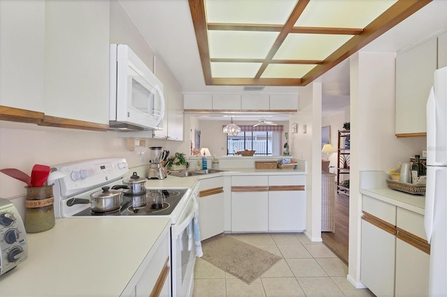 2004 Longpointe Cir Unit E2, Venice, FL 34293 - kitchen featuring white appliances, light countertops, light tile patterned flooring, white cabinets, and a chandelier