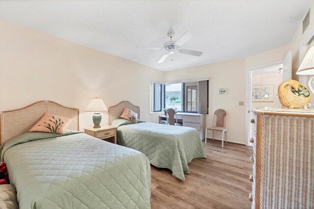2004 Longpointe Cir Unit E2, Venice, FL 34293 - bedroom with light wood-type flooring, ceiling fan, and a textured ceiling
