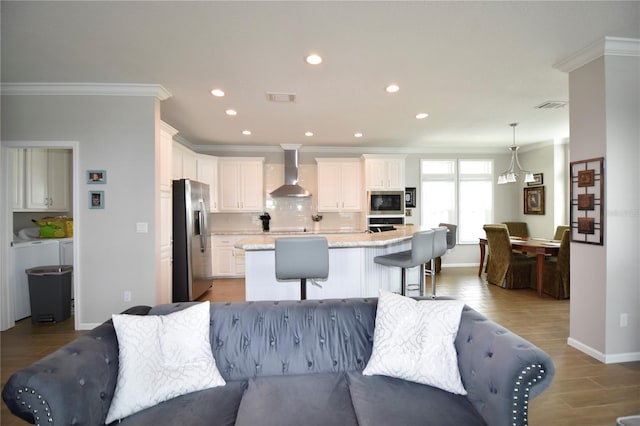 4354 Manatee Loop Unit 16A, Punta Gorda, FL 33950 - kitchen with stainless steel appliances, wall chimney exhaust hood, crown molding, decorative backsplash, and open floor plan