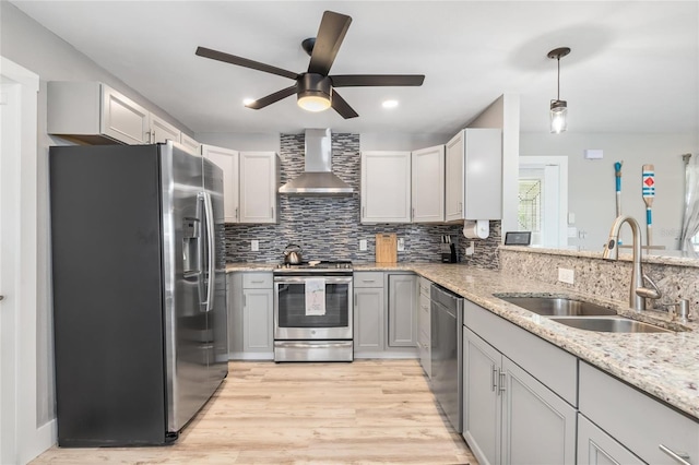 141 Baldwin Ct SE, Port Charlotte, FL 33952 - kitchen featuring appliances with stainless steel finishes, wall chimney exhaust hood, ceiling fan, light wood-style flooring, and backsplash