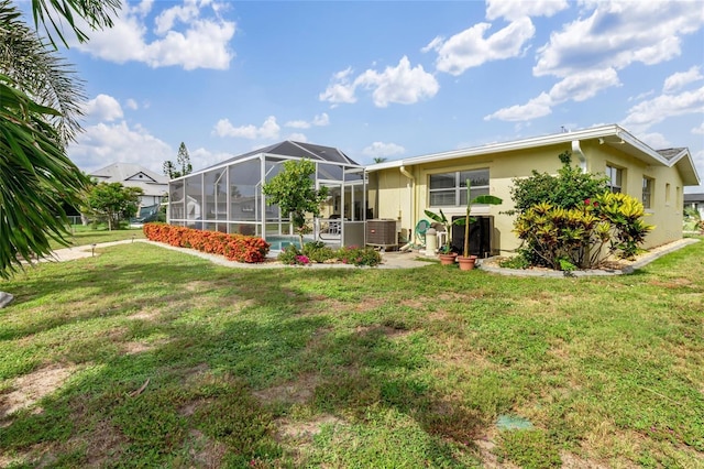 141 Baldwin Ct SE, Port Charlotte, FL 33952 - rear view of house featuring stucco siding, a yard, and a lanai