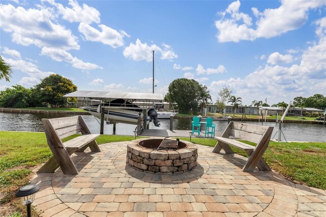141 Baldwin Ct SE, Port Charlotte, FL 33952 - view of patio featuring boat lift, a fire pit, a water view, and a boat dock