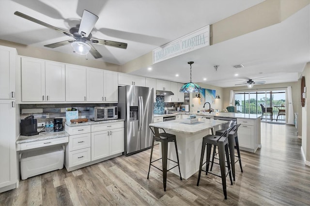 1401 S Mccall Rd Unit 205B, Englewood, FL 34223 - kitchen featuring stainless steel fridge, a peninsula, ceiling fan, tasteful backsplash, and light wood finished floors