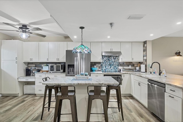 1401 S Mccall Rd Unit 205B, Englewood, FL 34223 - kitchen with appliances with stainless steel finishes, under cabinet range hood, light wood-type flooring, tasteful backsplash, and recessed lighting