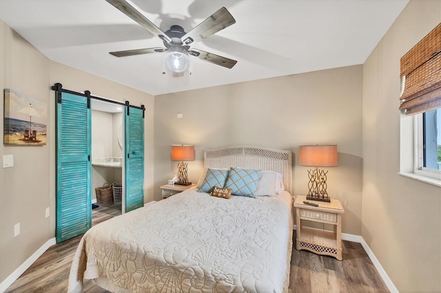 1401 S Mccall Rd Unit 205B, Englewood, FL 34223 - bedroom featuring a barn door, wood finished floors, and ceiling fan