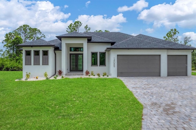 14089 Wenzel Ave, Port Charlotte, FL 33981 - prairie-style home with french doors, an attached garage, a front lawn, decorative driveway, and roof with shingles